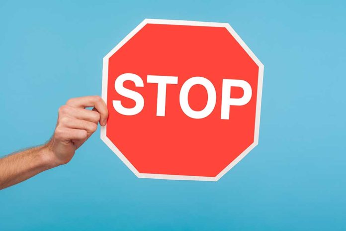 Closeup,Of,Male,Hand,Holding,Stop,Symbol,,Showing,Red,Traffic Sanctuary State's Governor Wants to Hit Pause