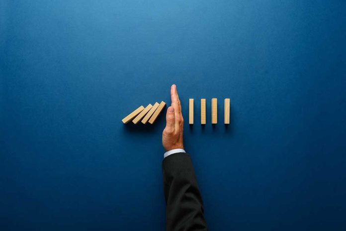 Top,View,Of,Businessman,Hand,Stopping,Falling,Dominos,In,A