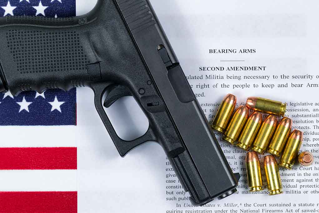 359759447 featured image Gun and bullets on Second Amendment document.