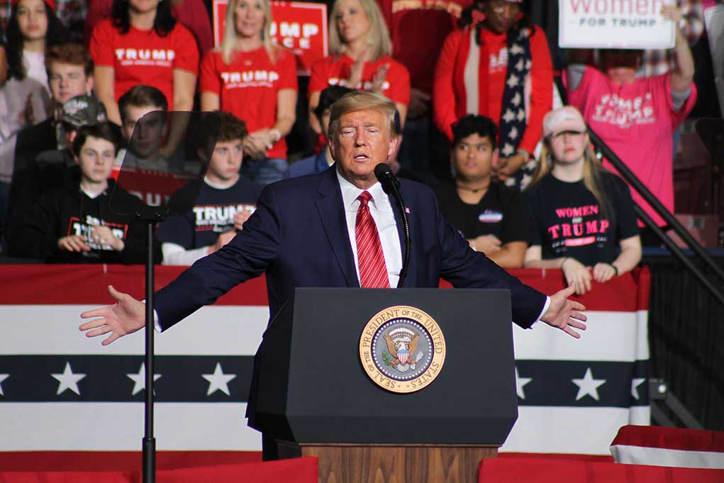1662925921 featured image Politician speaking at rally with supporters behind him.