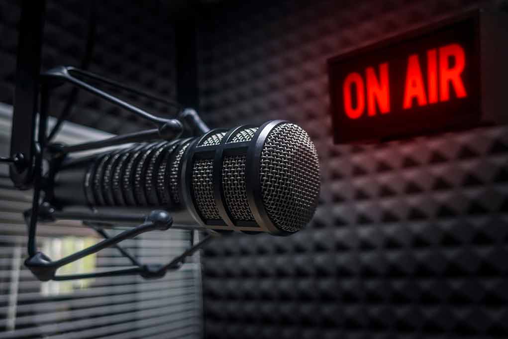 1218528058 featured image Microphone in studio with "On Air" sign.