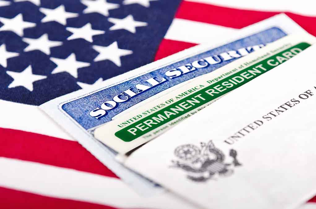 Support for Trump’s Birthright Citizenship Rollback Surpasses Opposition, Poll Shows Social Security card and green card on flag.
