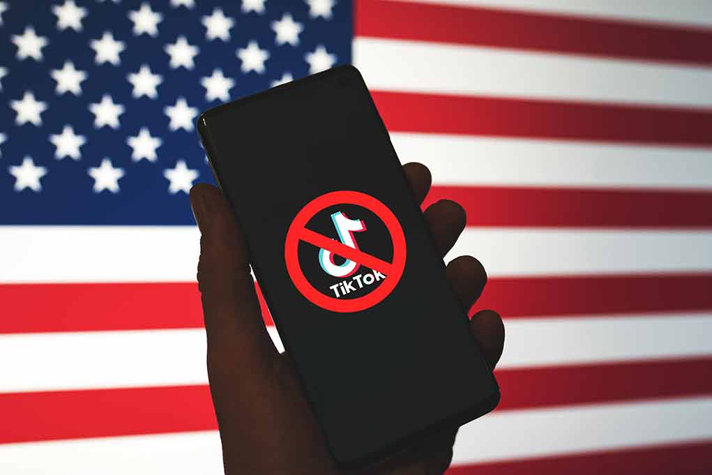 2265047307 featured image Phone displaying TikTok ban symbol in front of flag