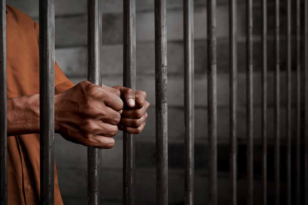 772489252 featured image Hands gripping prison cell bars tightly