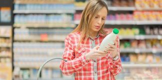 Woman reading label in grocery store aisle