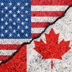 USA and Canada flags divided by a crack