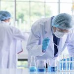 Scientists in lab coats conducting experiments with beakers