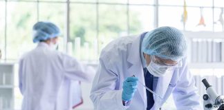 Scientists in lab coats conducting experiments with beakers