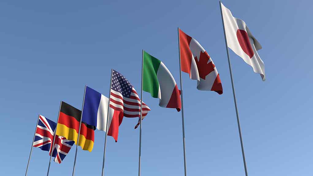 1437085796 featured image Flags of seven countries against clear blue sky.