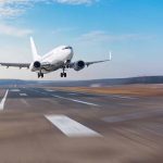 Airplane landing on a runway under clear sky