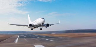 Airplane landing on a runway under clear sky