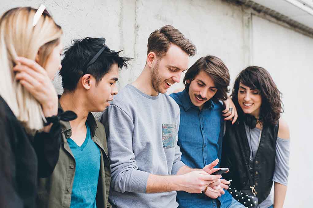 Group of friends looking at a smartphone.