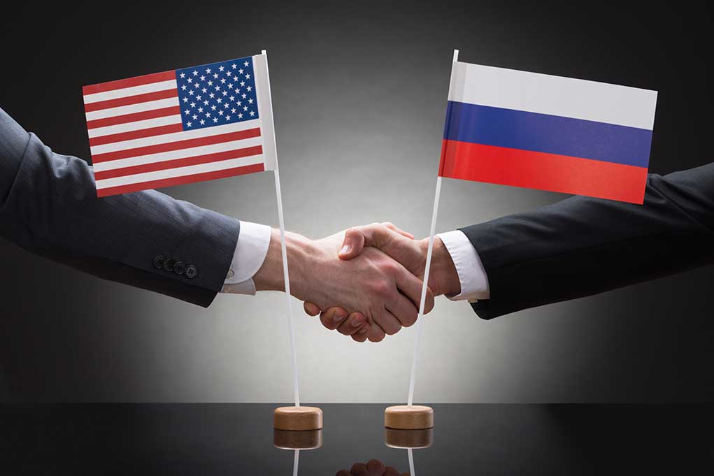 282618053 featured image Two people shaking hands with flags displayed