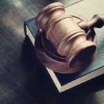 Wooden gavel resting on thick book