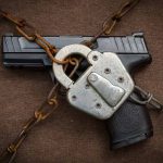 Gun secured with chains and padlock on fabric