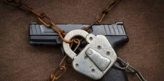 Gun secured with chains and padlock on fabric