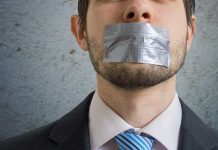 Person with duct tape over mouth in suit