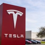 Tesla sign in front of dealership.