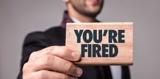 Man holding Youre Fired sign card