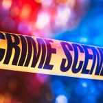 Yellow crime scene tape with blurred lights background