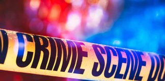 Yellow crime scene tape with blurred lights background