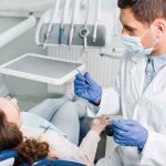 Dentist examining a patient in a dental chair.