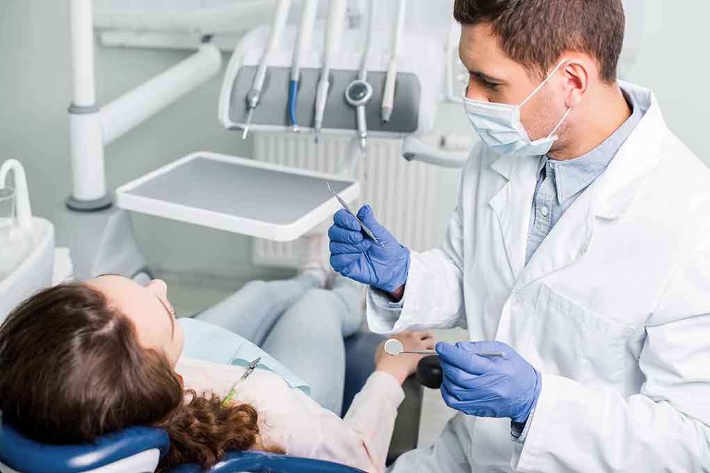 1317916853 featured image Dentist examining a patient in a dental chair.