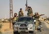 Men in military gear on pickup truck