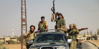 Men in military gear on pickup truck