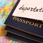 Passports stacked with deportation note on top.