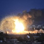 Large explosion with smoke over a cityscape night