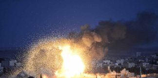 Large explosion with smoke over a cityscape night