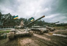 Tanks with flags in muddy forest environment