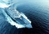 Military ship sailing swiftly on ocean waters