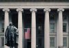 US Treasury Department building with statue and flag