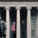 US Treasury Department building with statue and flag
