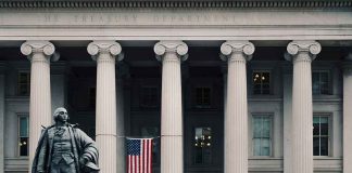 US Treasury Department building with statue and flag