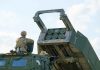 Soldier with military vehicle and missile launcher.