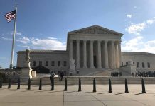 U S Supreme Court Building with flag and people outside