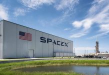 SpaceX building with American flag and launch pad