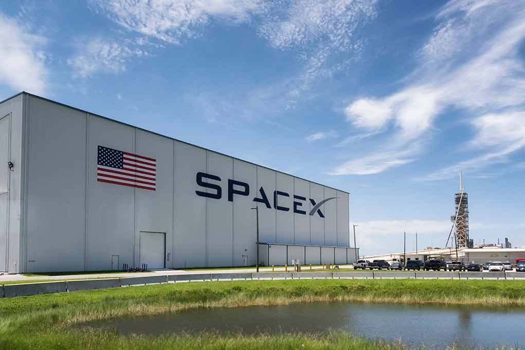 SpaceX building with American flag and launch pad