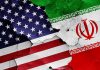 Cracked American and Iranian flags painted on a wall