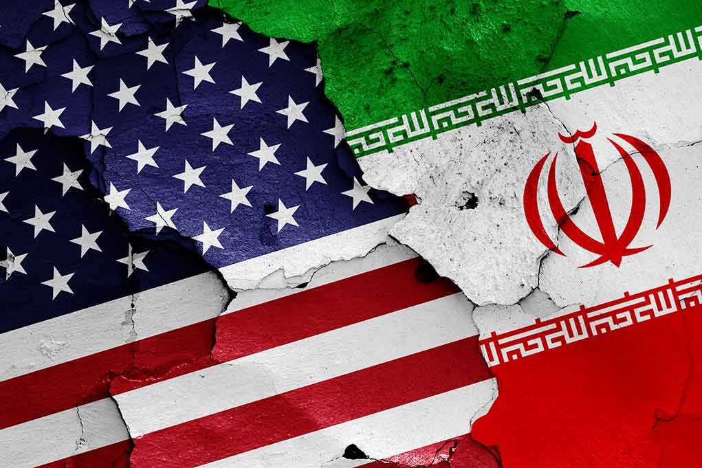 Cracked American and Iranian flags painted on a wall