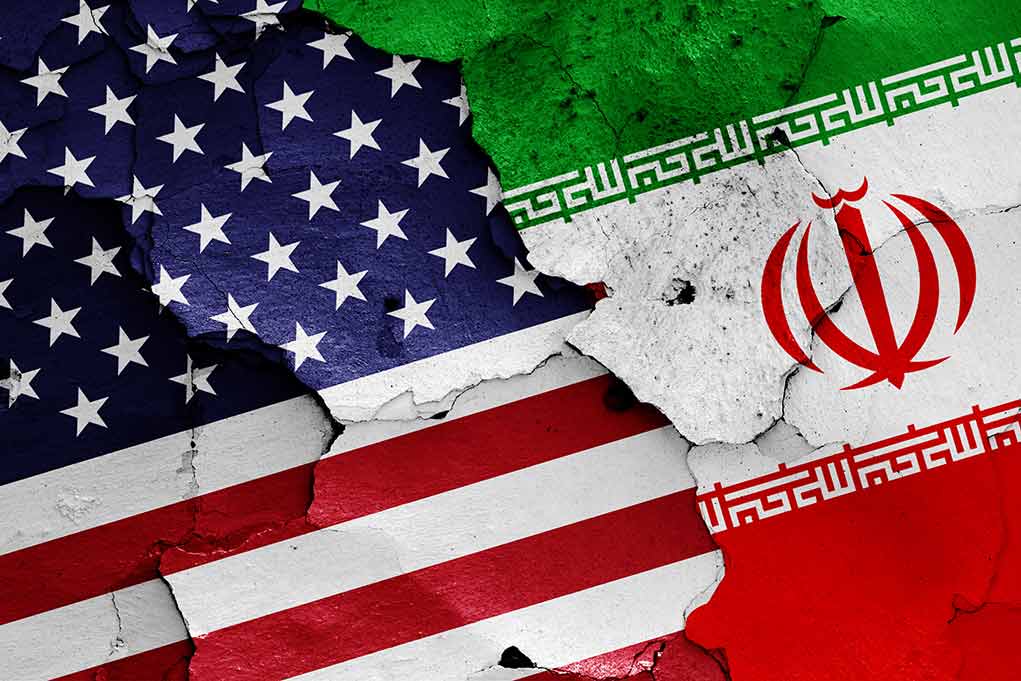 Cracked American and Iranian flags painted on a wall