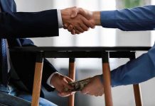 Handshake and exchange of money under the table