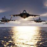 Five fighter jets flying over the ocean