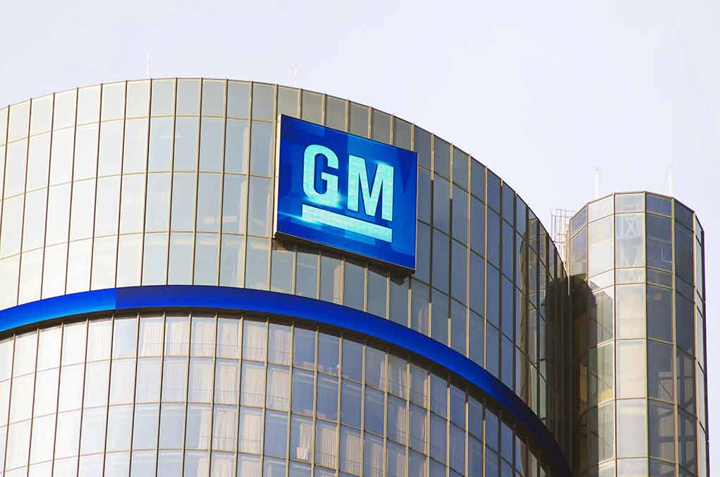 Glass building with large GM logo on top