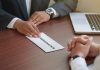 Handing in a resignation letter across a table