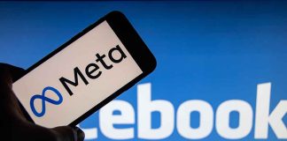 Meta on phone screen Facebook in background