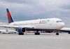 Delta Airlines airplane on airport runway cloudy sky